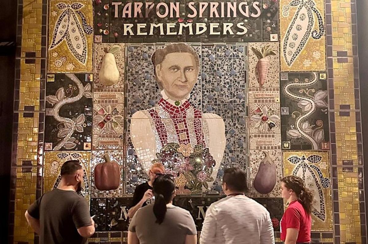 egy csoport ember áll egy nagy falfestmény előtt