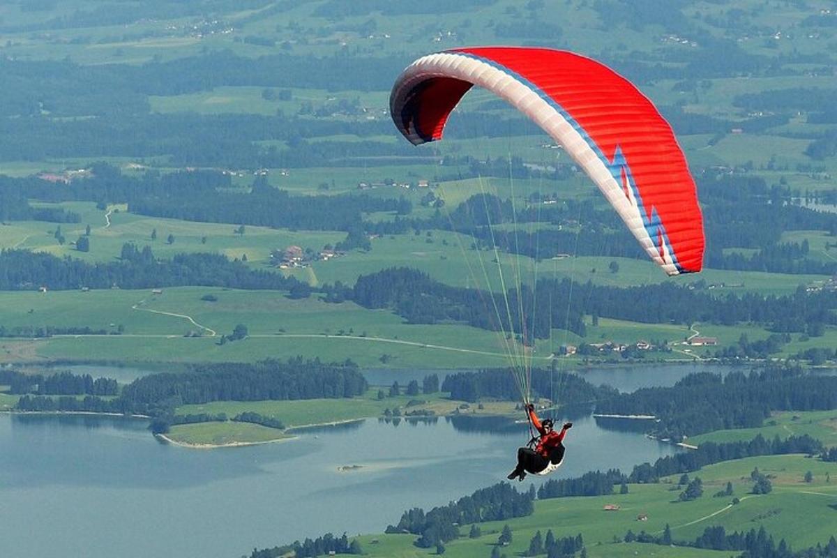 oseba, ki se s padalom spušča nad vodno površino