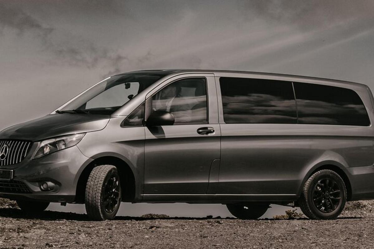 o minivană argintie parcată pe un teren de pământ