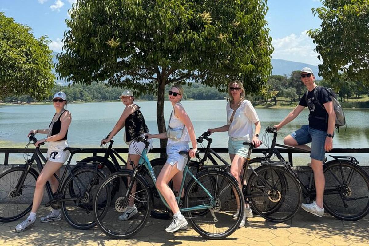 un grup de oameni stând pe bicicletele lor lângă apă
