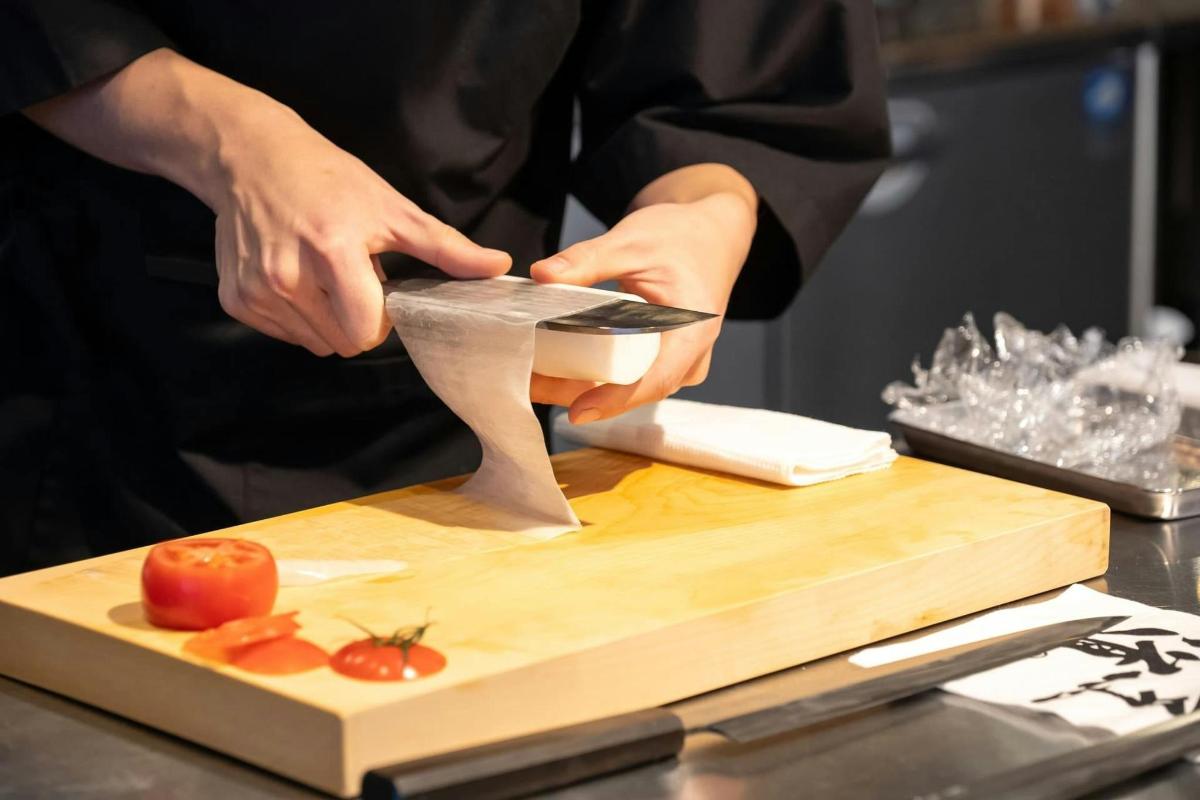 seseorang memotong tomato pada papan pemotong