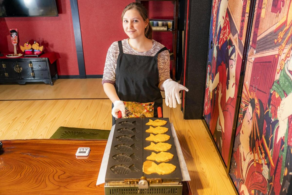una dona amb davantal preparant menjar a taula