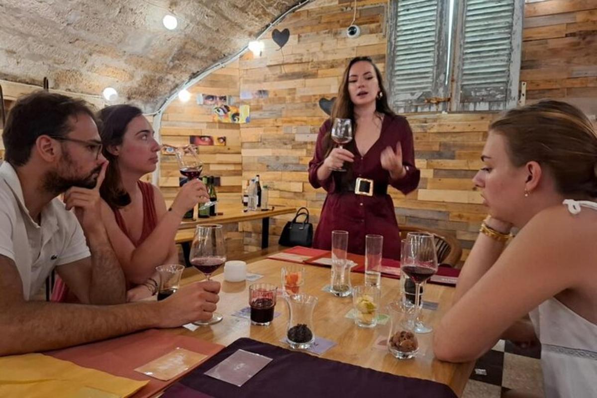skupina lidí sedících kolem stolu a popíjejících víno