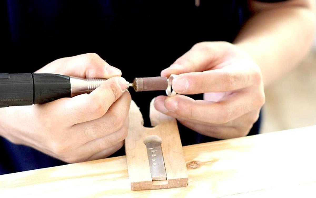 a person cutting a piece of wood with a knife