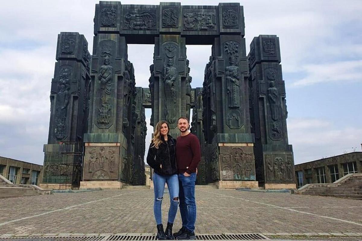 Un hombre y una mujer de pie frente a un arco.