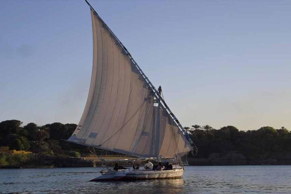 a boat with a large white sail on the water