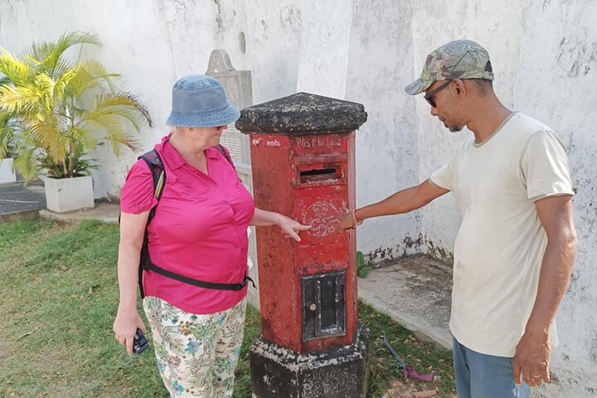 a man and a woman standing next to a red post box