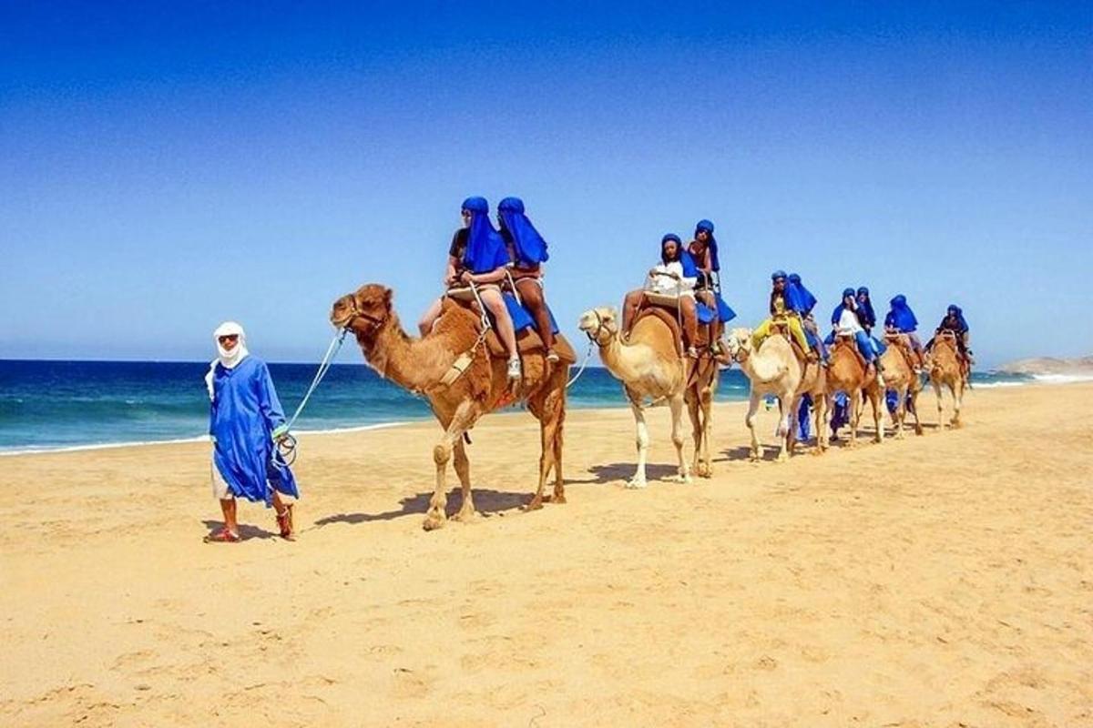 مجموعة من الناس يركبون الجمال على الشاطئ
