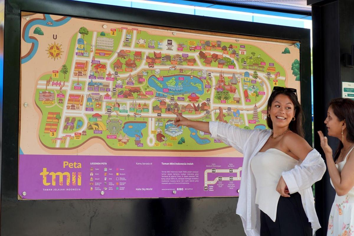 a woman standing next to a map of a resort