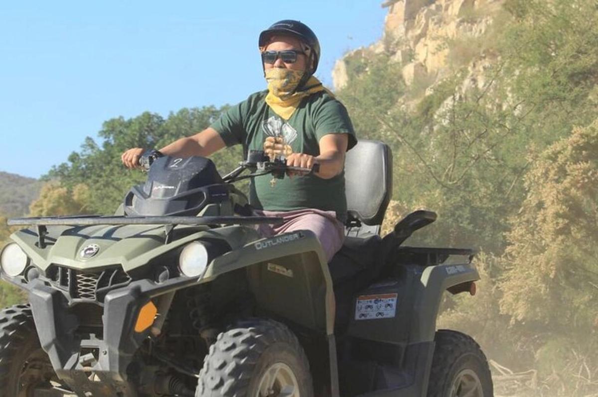 un uomo è seduto su un quad su una montagna
