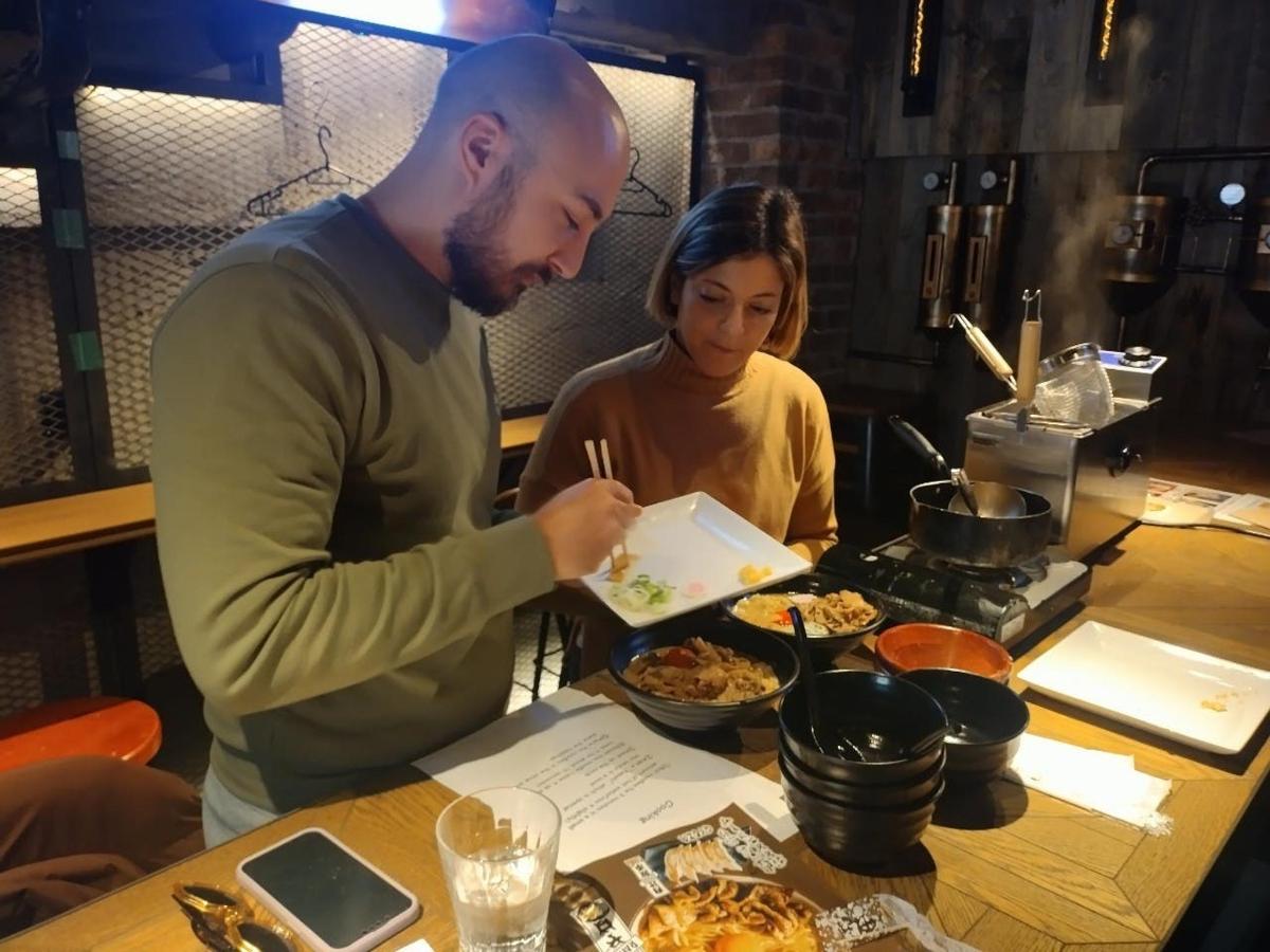 a man and a woman eating food at a table