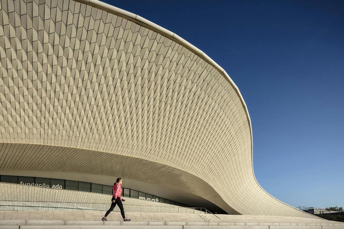 a woman walking in front of a large building