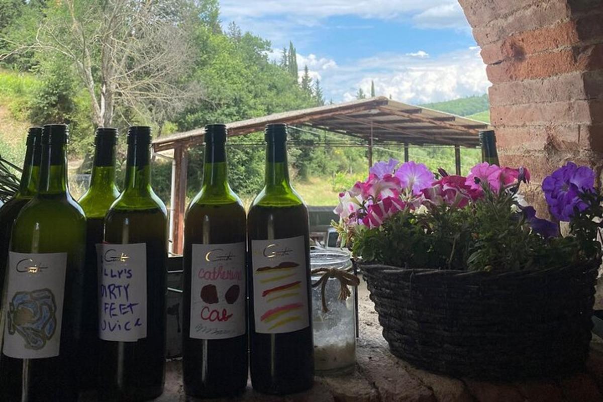 quatro garrafas de vinho ao lado de uma cesta de flores