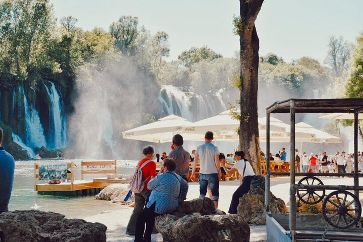 a group of people standing in front of a waterfall