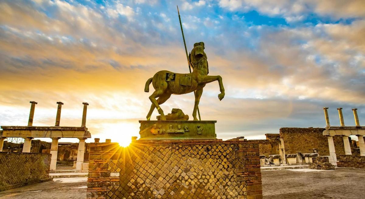 a statue of a man riding a horse in front of a building