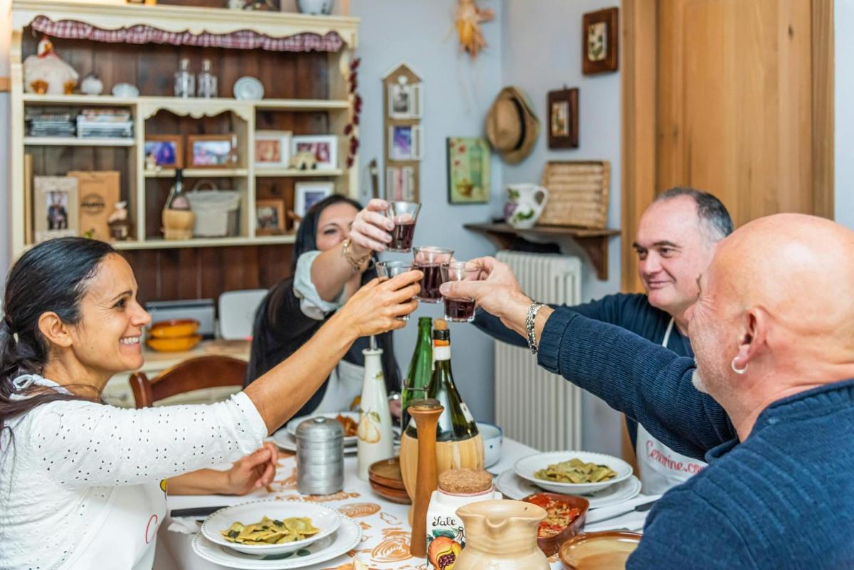 un grup de oameni așezați în jurul unei mese, bând vin