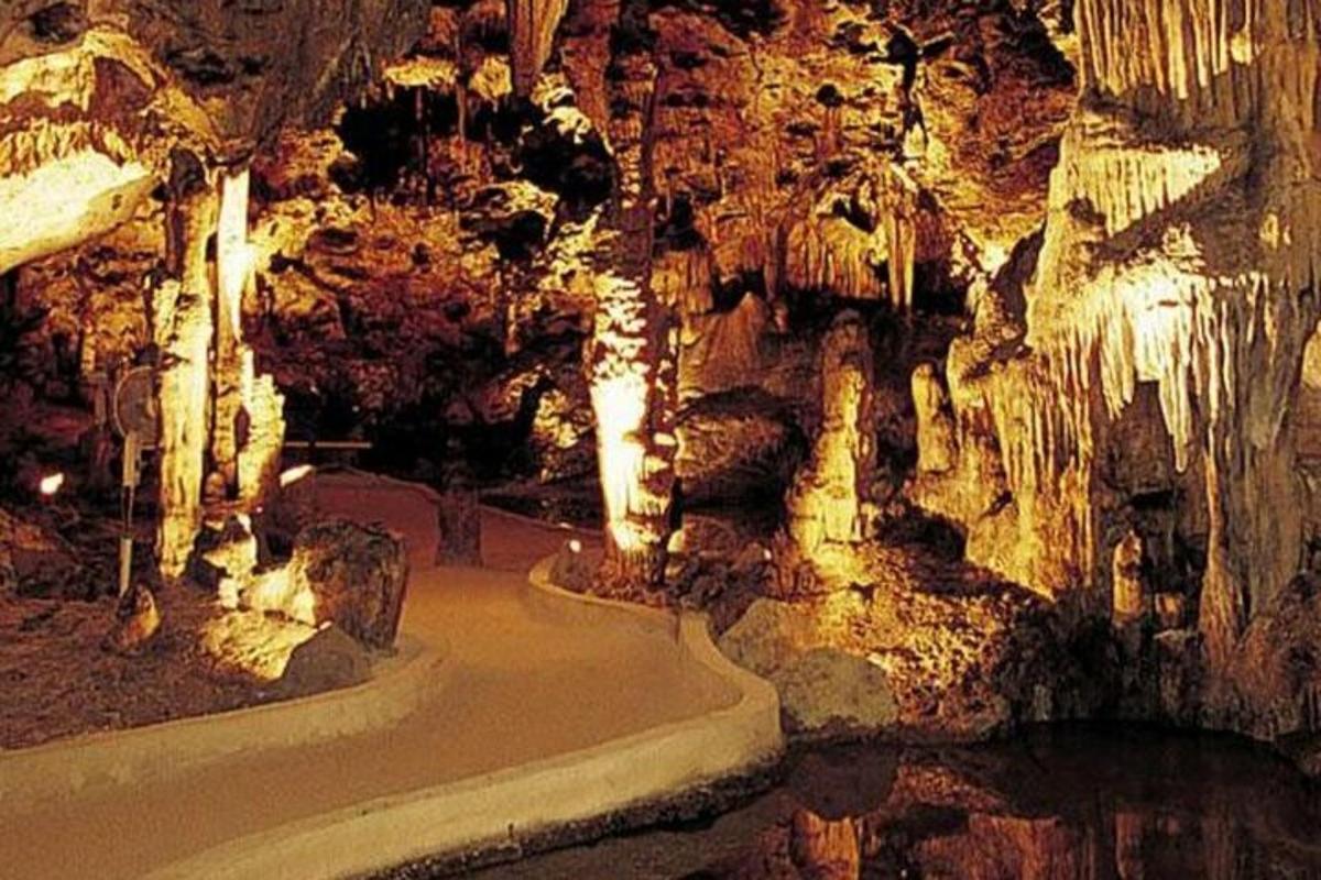 a cave with a rock wall and a walk way