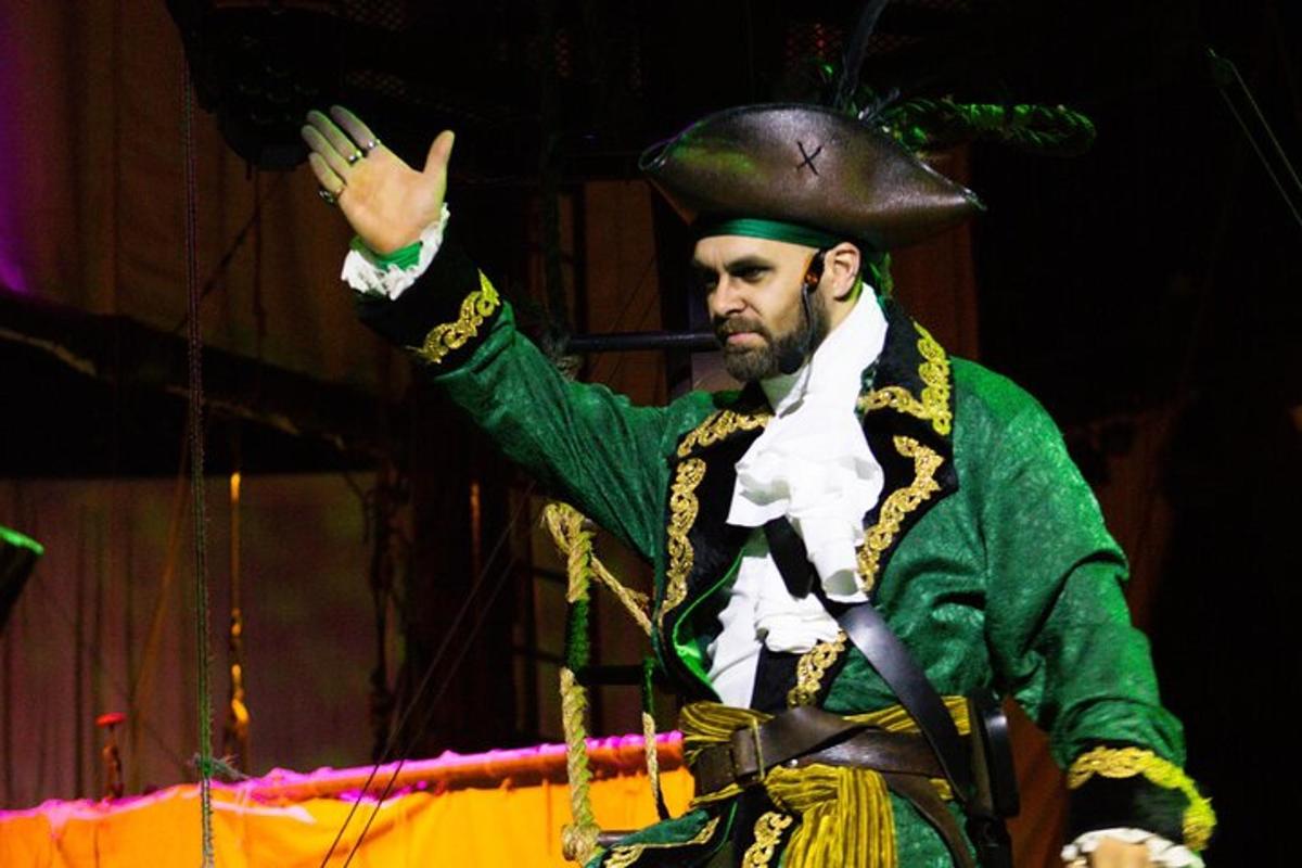 a man wearing a hat and costume on a stage