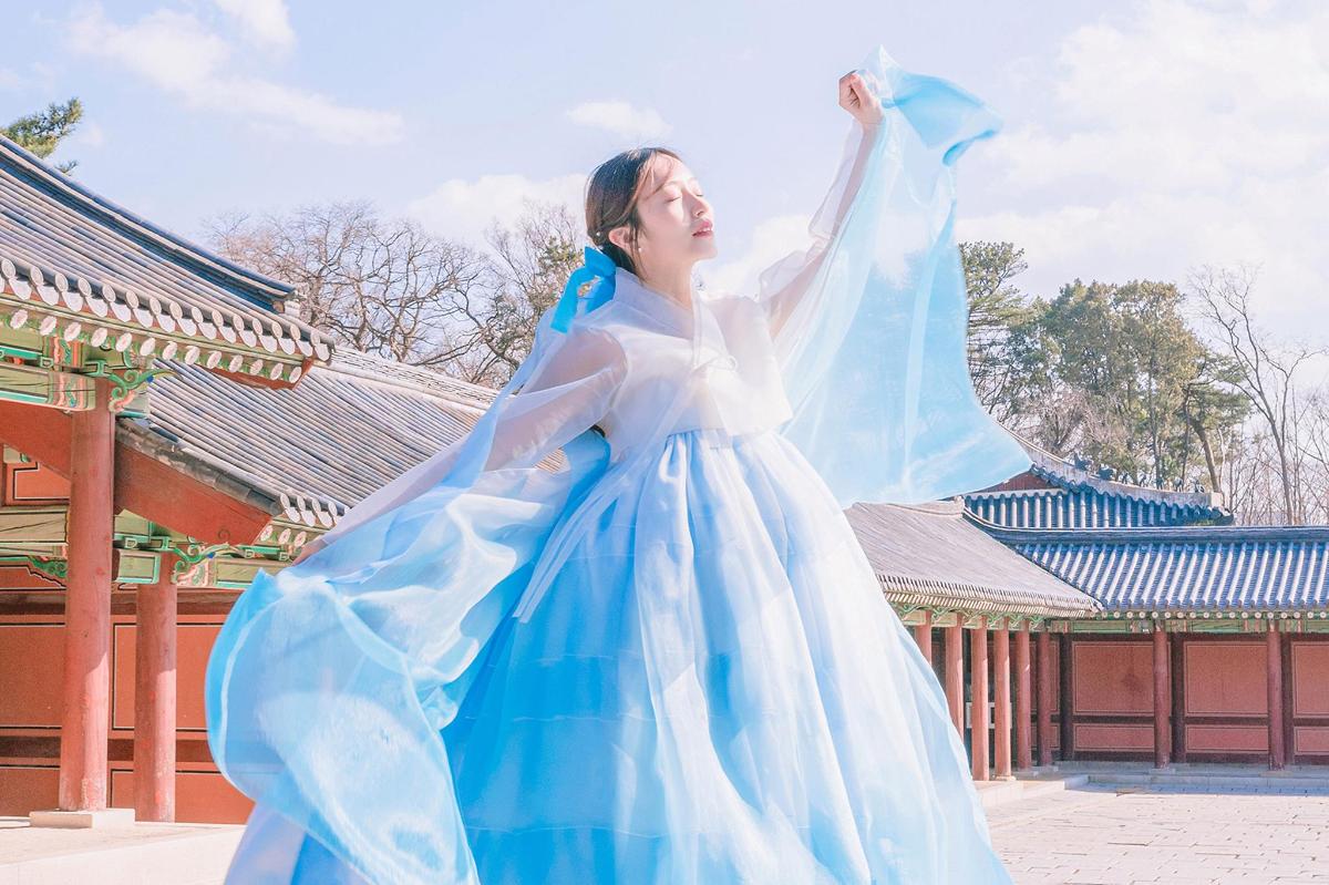 a woman in a blue and white dress dancing