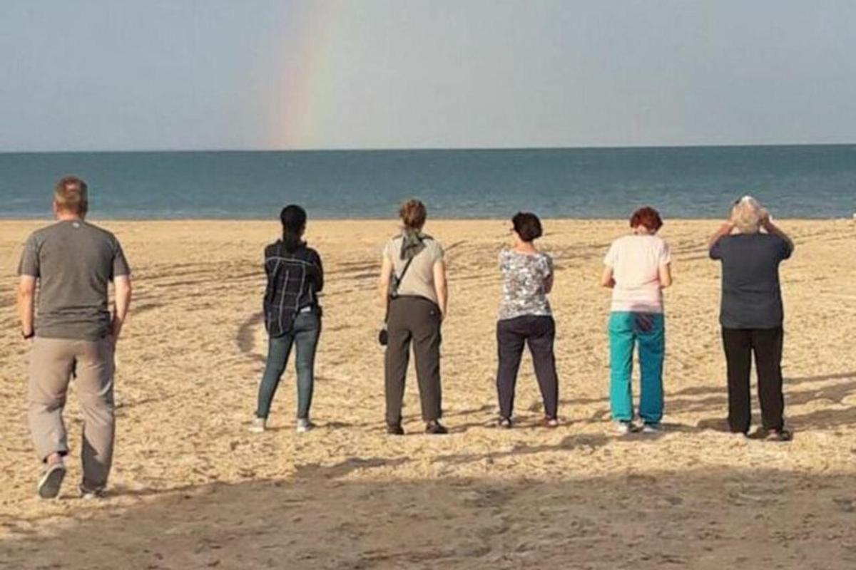 a group of people standing on the beach