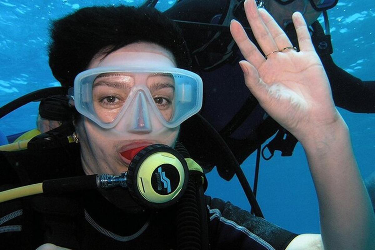 una donna che indossa una maschera da sub e occhialini sott'acqua