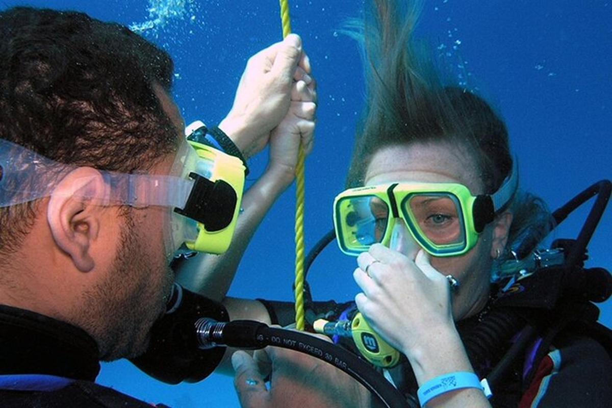 due persone con gli occhiali protettivi sul viso mentre sono sott'acqua