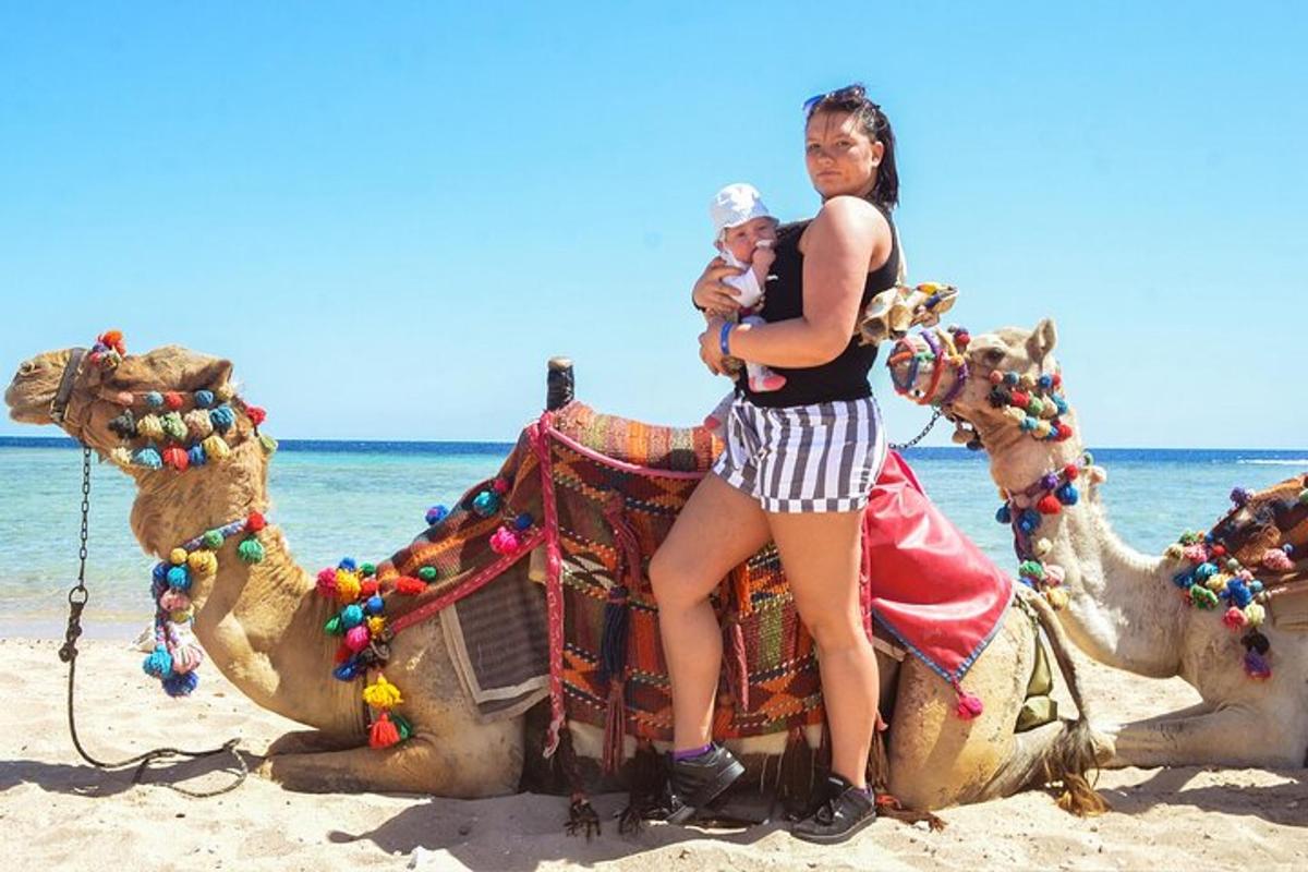 una donna seduta su un cammello sulla spiaggia