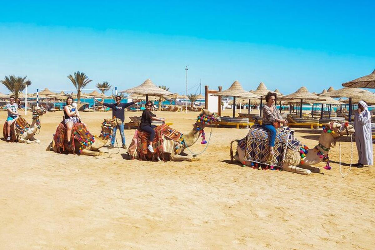 un gruppo di persone a cavallo di cammelli sulla spiaggia