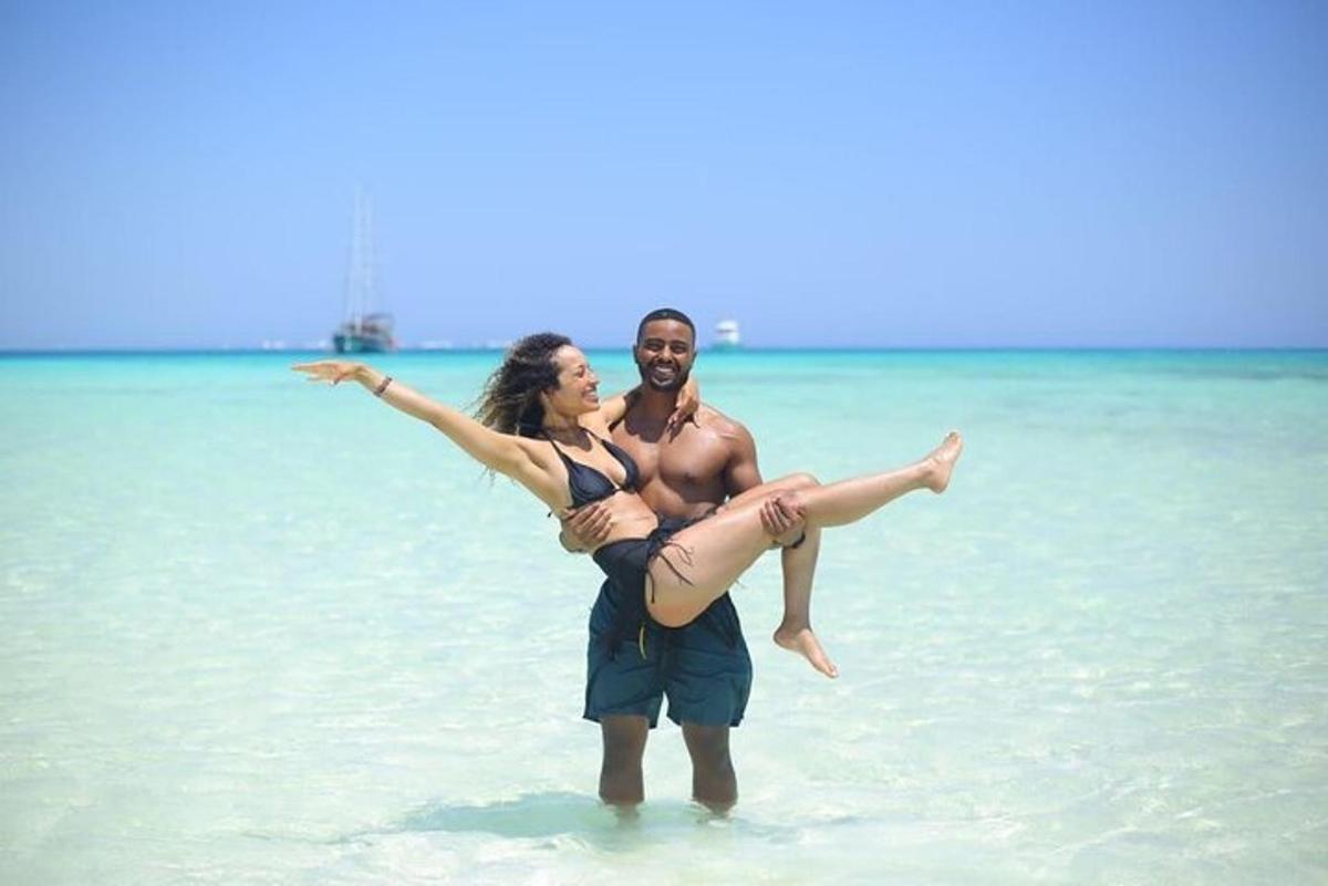 Un hombre y una mujer de pie en el agua en la playa.