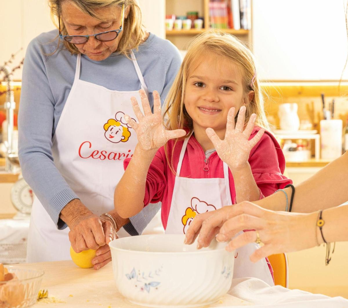 una donna e una ragazza in cucina che mescolano una ciotola