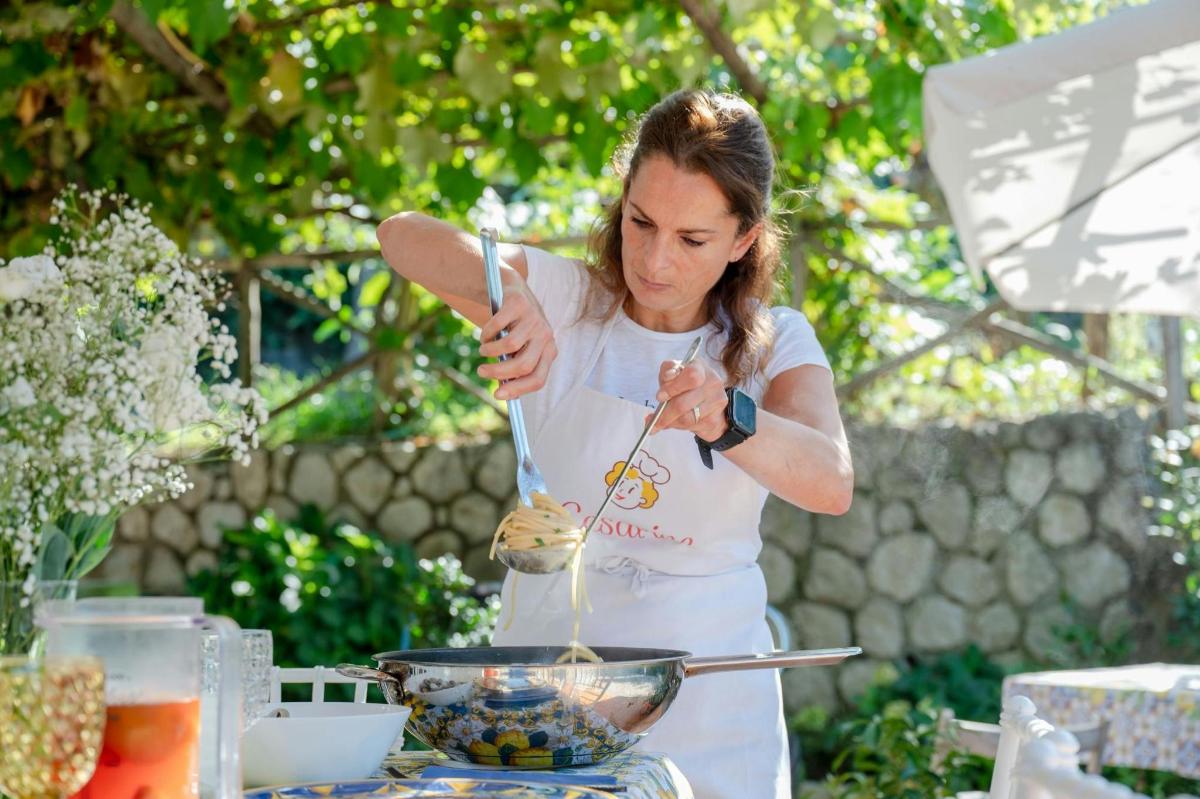 una donna sta mescolando una ciotola di cibo con le pinze
