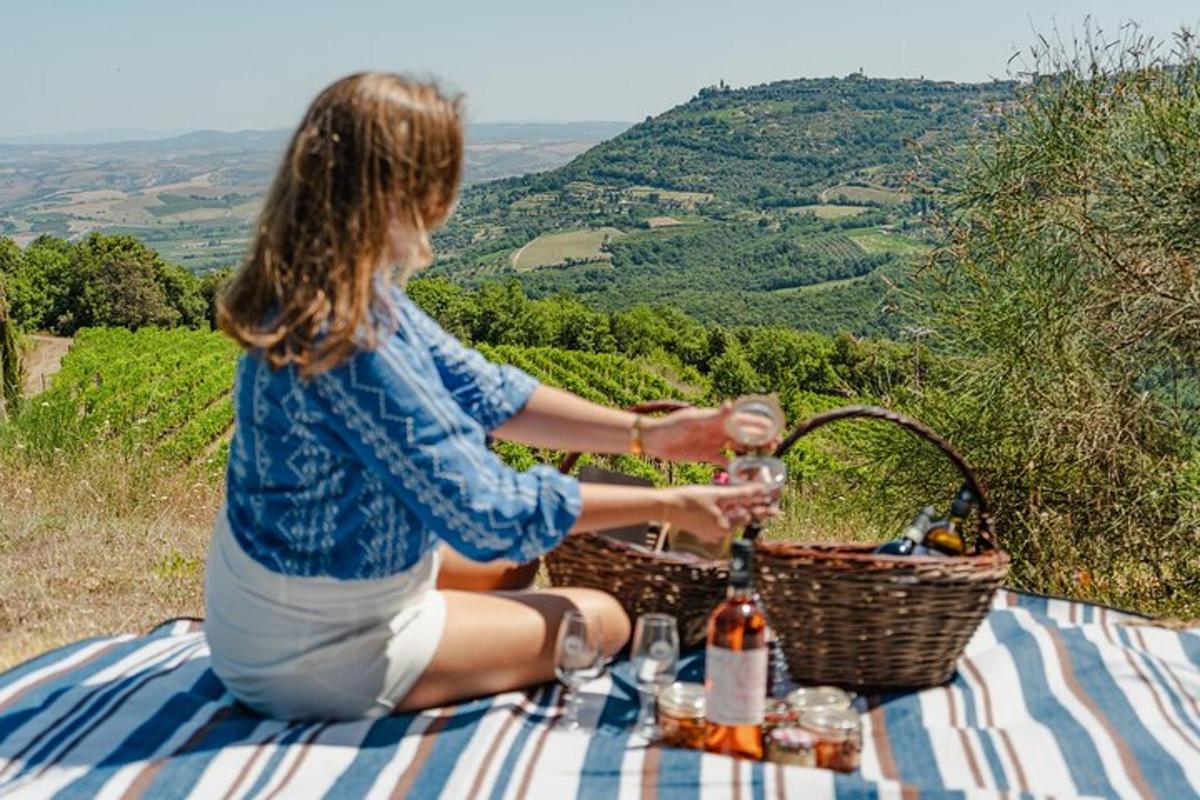 una donna seduta a un tavolo da picnic che beve vino