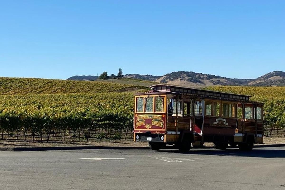 a trolley car parked in front of a vineyard