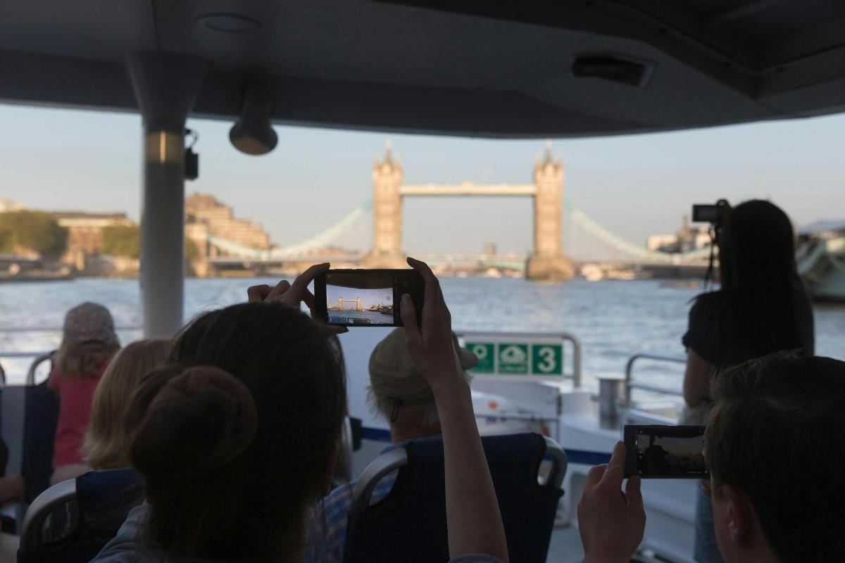 un gruppo di persone che scatta foto del Tower Bridge