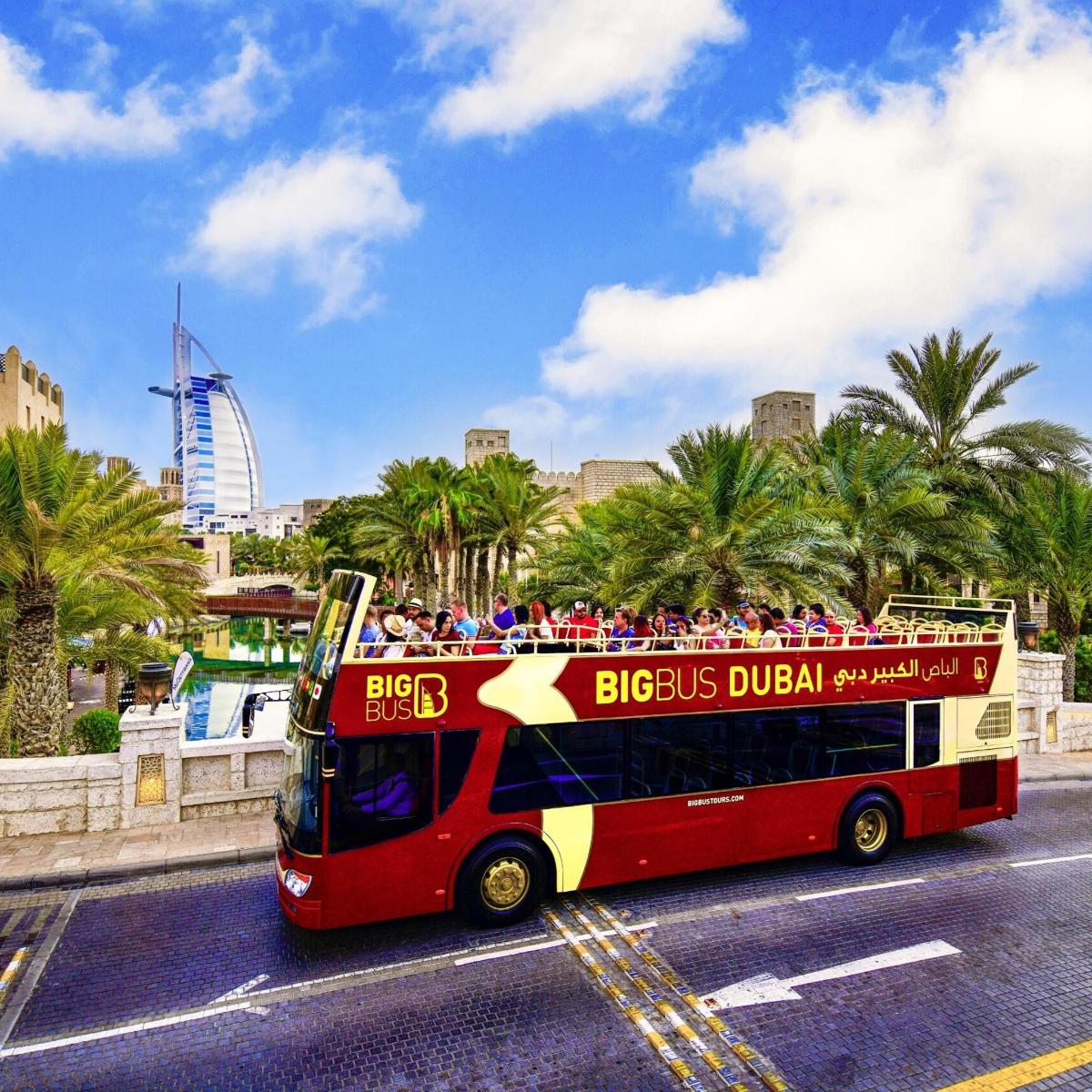 a red double decker bus with people on the top
