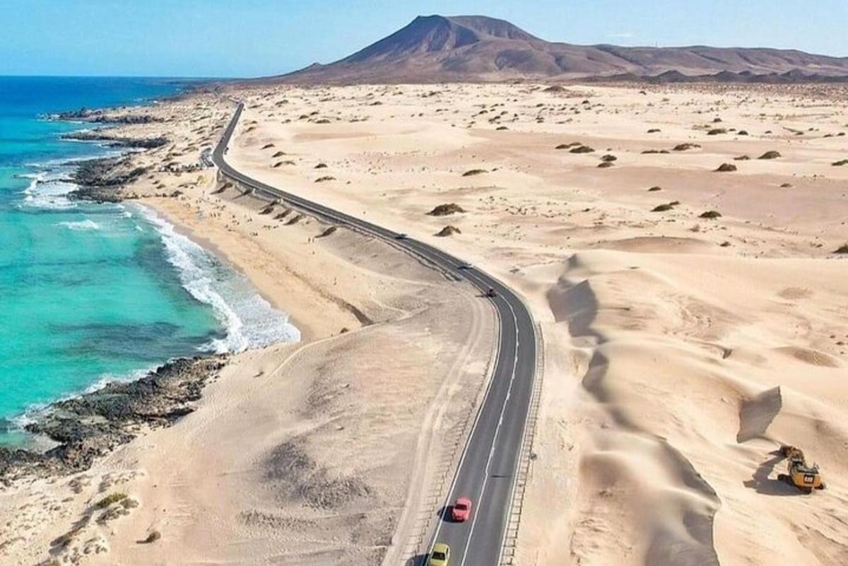 a road in the desert next to the ocean