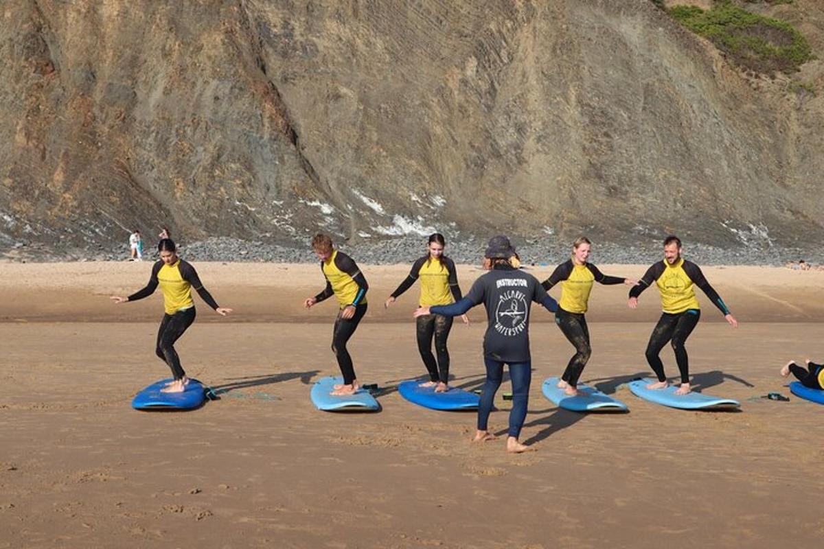 Un grupo de personas de pie sobre tablas de surf en una playa.