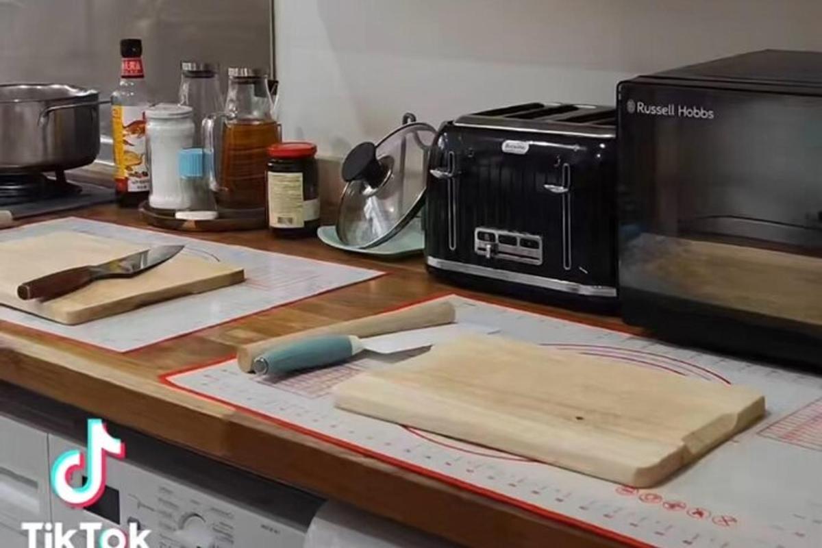 un taulell de cuina amb una taula de tallar i un microones