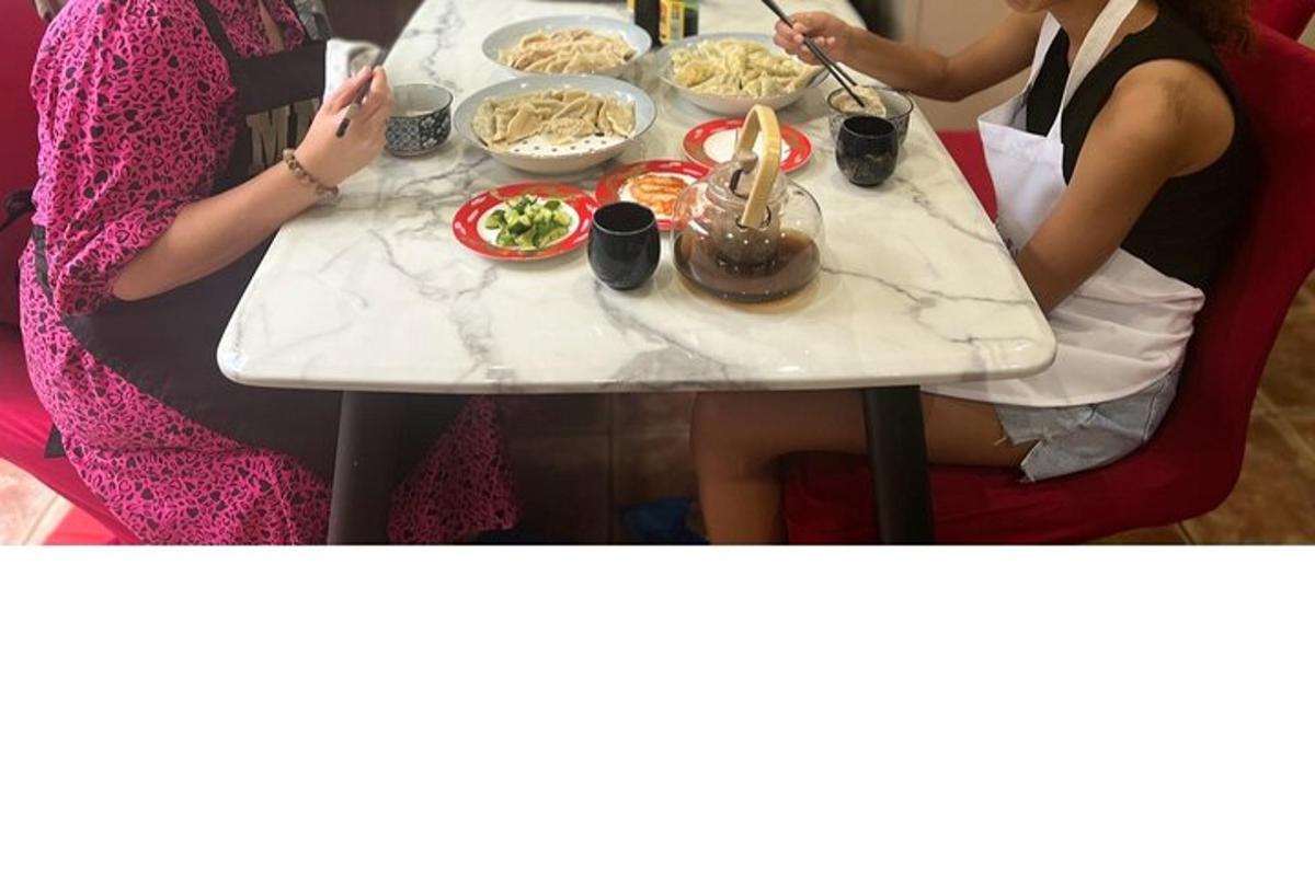 dua wanita duduk di meja dengan makanan di atasnya