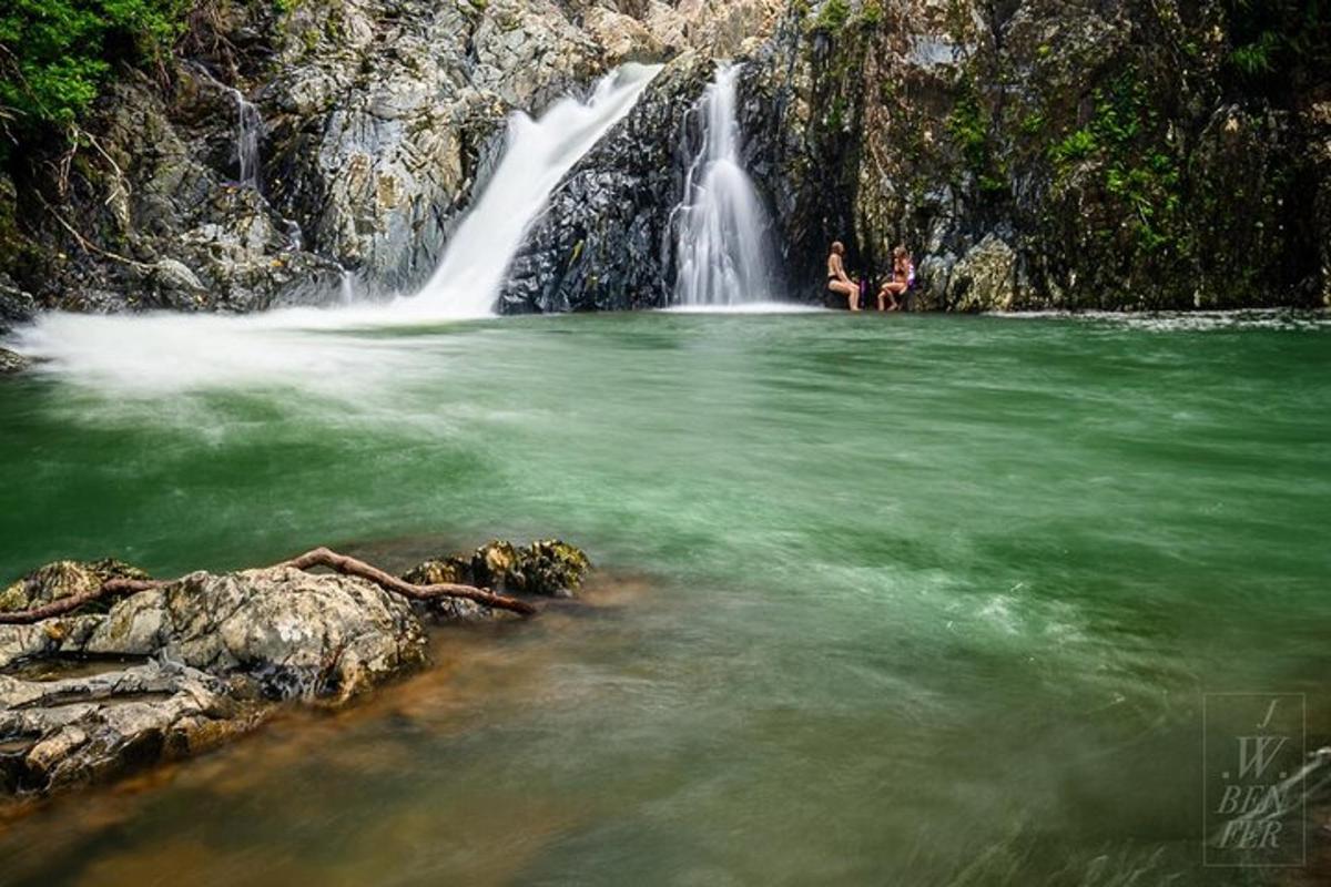 a group of people swimming in a waterfall