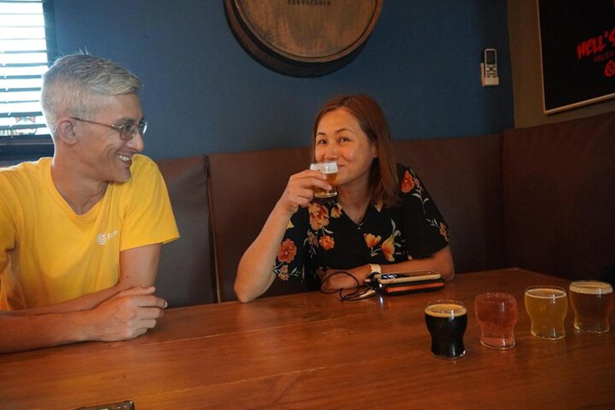 muž a žena sedia za stolom a pijú pivo