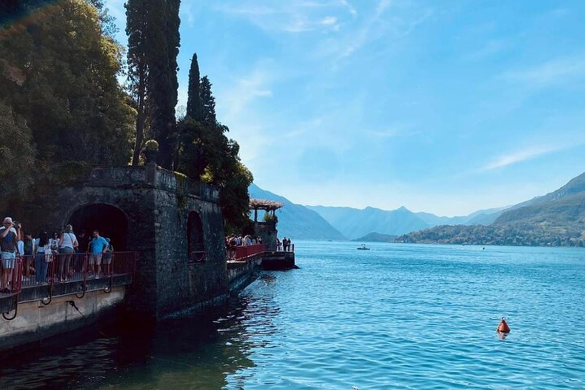 un gruppo di persone in piedi su un ponte sopra uno specchio d'acqua
