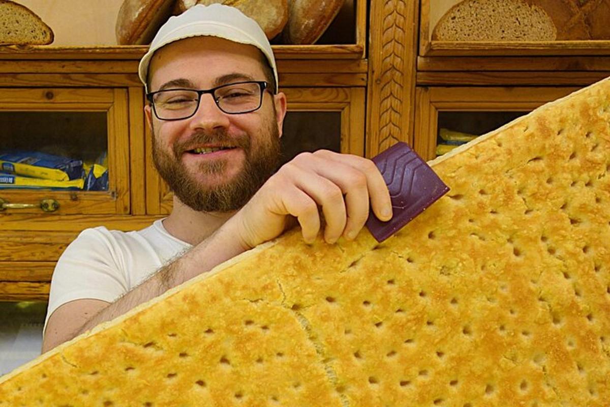 bir adam büyük bir yiyecek parçası tutuyor