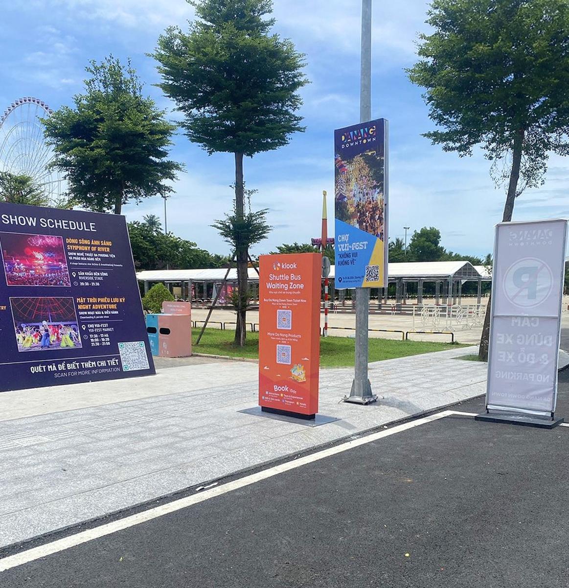 a group of signs on a sidewalk in a park