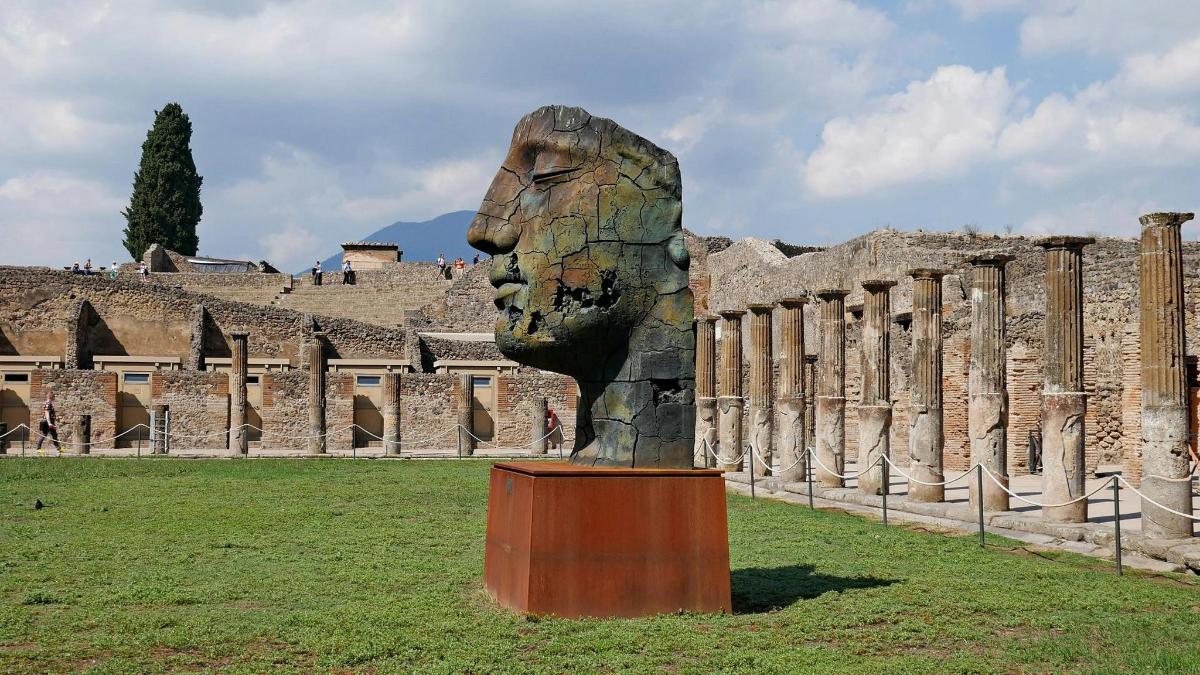 a statue of a head in front of a building