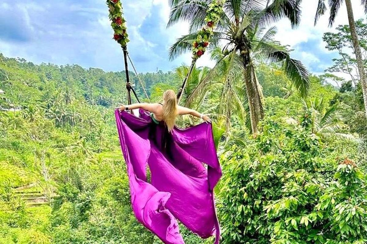 una donna con un vestito rosa che si dondola su un'amaca
