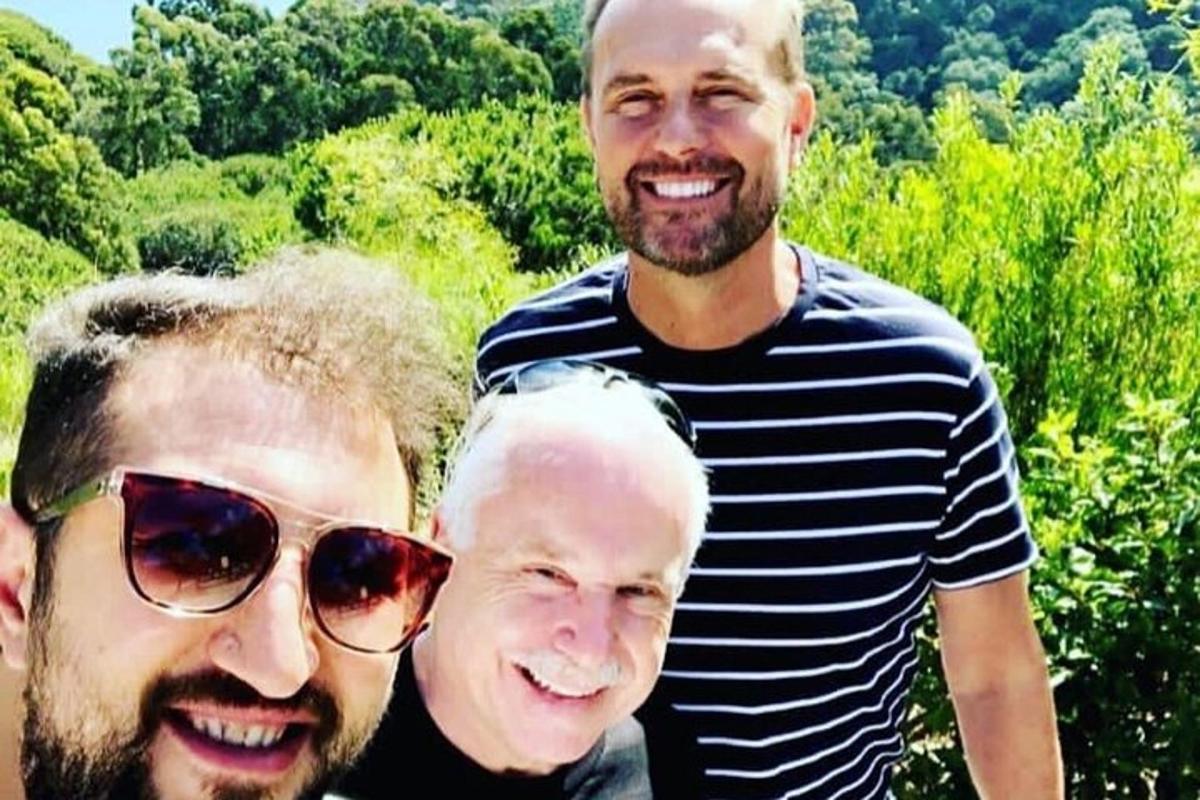 група од три мушкарца позира за фотографију