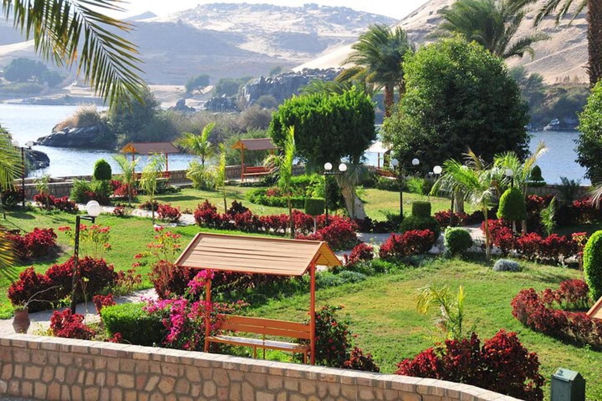 un parco con una panchina, dei fiori e uno specchio d'acqua