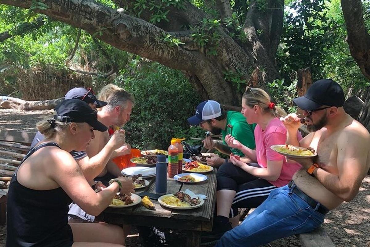 un gruppo di persone sedute a un tavolo da picnic che mangiano cibo