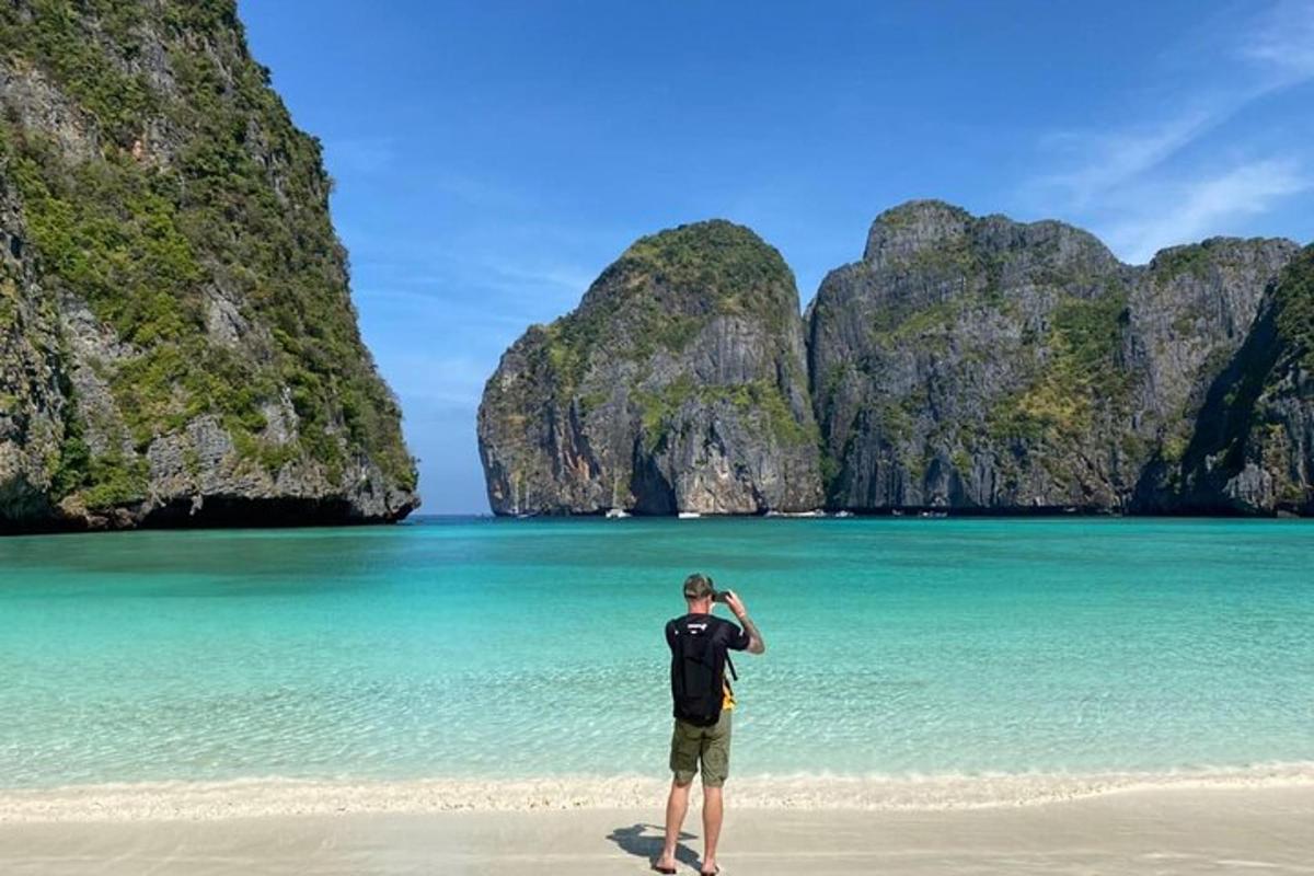 moški, ki stoji na plaži pred oceanom